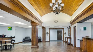 A spacious lobby with a wooden ceiling, a reception desk, and a clock on the wall. - Quality Inn & Suites Monterey I-40 (Monterey)