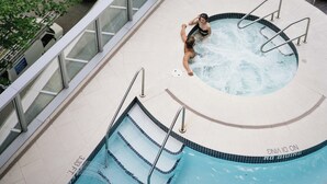 A rooftop pool with a glass balustrade, a hot tub, and a view of the surrounding cityscape. - Hyatt Vancouver Downtown Alberni (Vancouver)