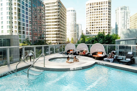 Una piscina al aire libre, sillones reclinables de piscina