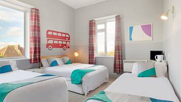 A hotel room with two beds, a window with curtains, a wall-mounted lamp, and a painting.