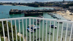 Une ville côtière dotée d’un port de plaisance, d’une plage et de bâtiments qui se dressent à l’arrière-plan.