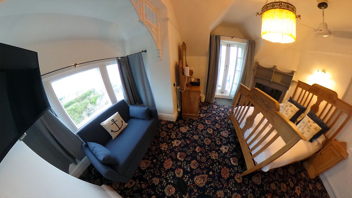 Una stanza con un letto, una finestra con tende, un lampadario e un tappeto decorato.