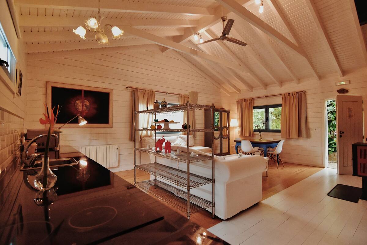 A spacious room with a high ceiling, a dining area, and a kitchen.