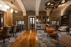 Ein geräumiges Wohnzimmer mit Holzboden, einer Essecke mit Stühlen und einem Sofa.