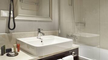 Un baño moderno con un espejo grande, un lavabo, una ducha y una bañera.