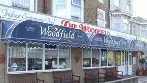 En byggnad med en skylt där det står ”Woodfield” och ”Inomhuspool”.