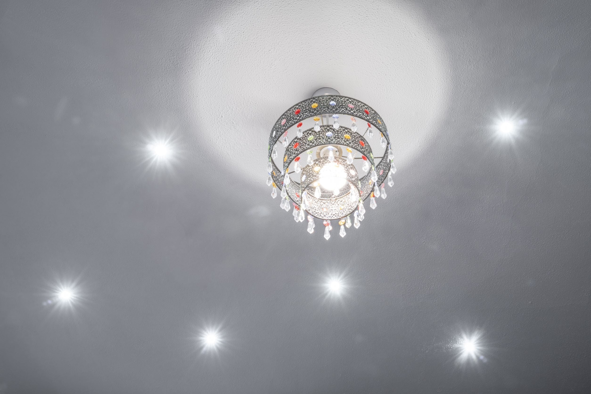 A ceiling light fixture with a decorative design and multiple bulbs.