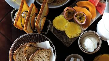 A breakfast setting with toast, pancakes, fruit, and a cup of coffee.