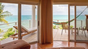 Un balcon avec vue sur l’océan, un hamac et des chaises longues.