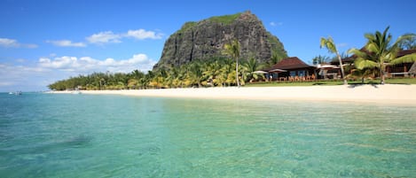 On the beach, white sand, sun loungers, beach umbrellas