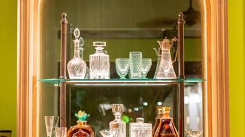 A bar area with glass shelves displaying bottles and glasses.