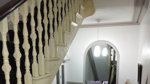 Una escalera con balaustres blancos y una barandilla de madera oscura que conduce a una plataforma.