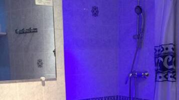 Un baño con ducha, perchero y espejo.