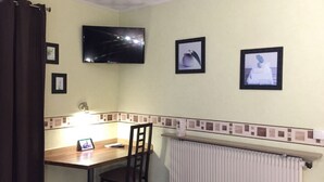 A small room with a desk, chair, and a television mounted on the wall. - Hotel Saint Aignan (Orléans)