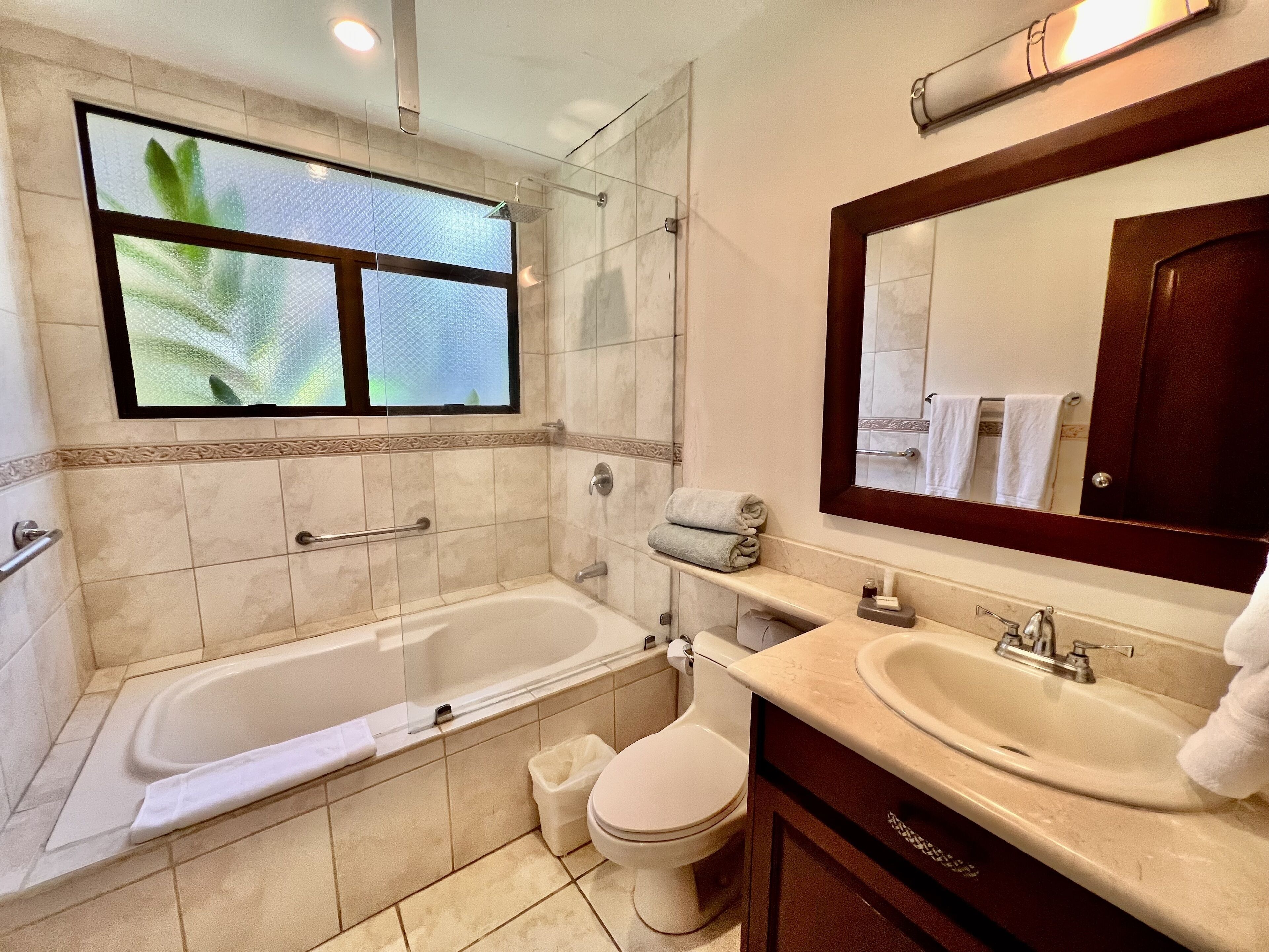 Un baño moderno con bañera, inodoro y dos lavabos.