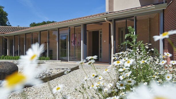 A modern building with a glass facade and a covered patio area.