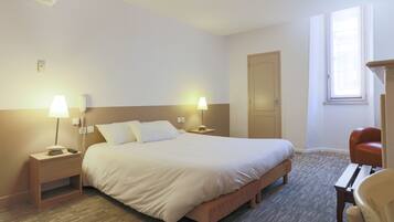 Een hotelkamer met een groot bed, twee nachtkastjes met lampen, een houten stoel en een deur.