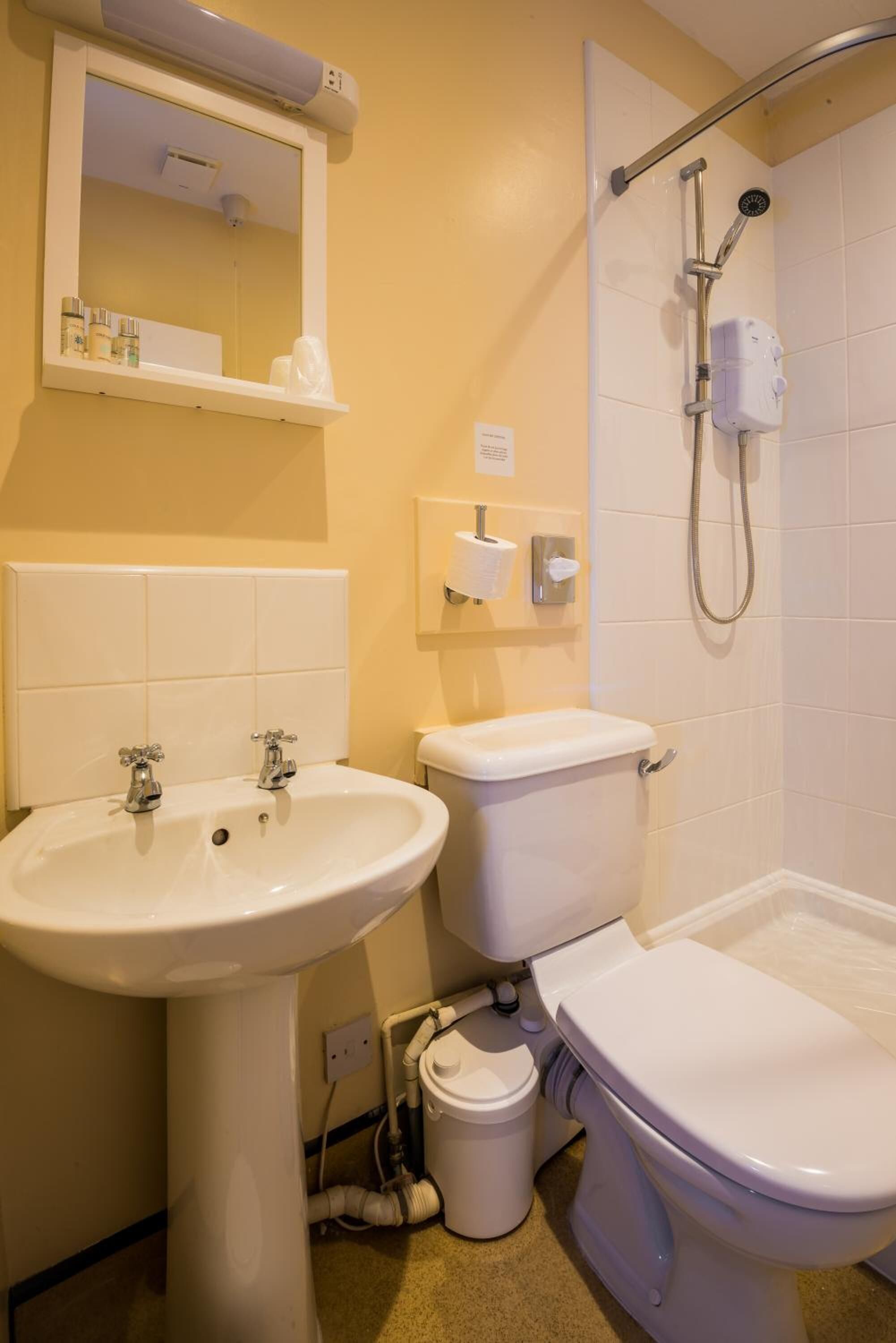 A bathroom with a sink, toilet, and shower.