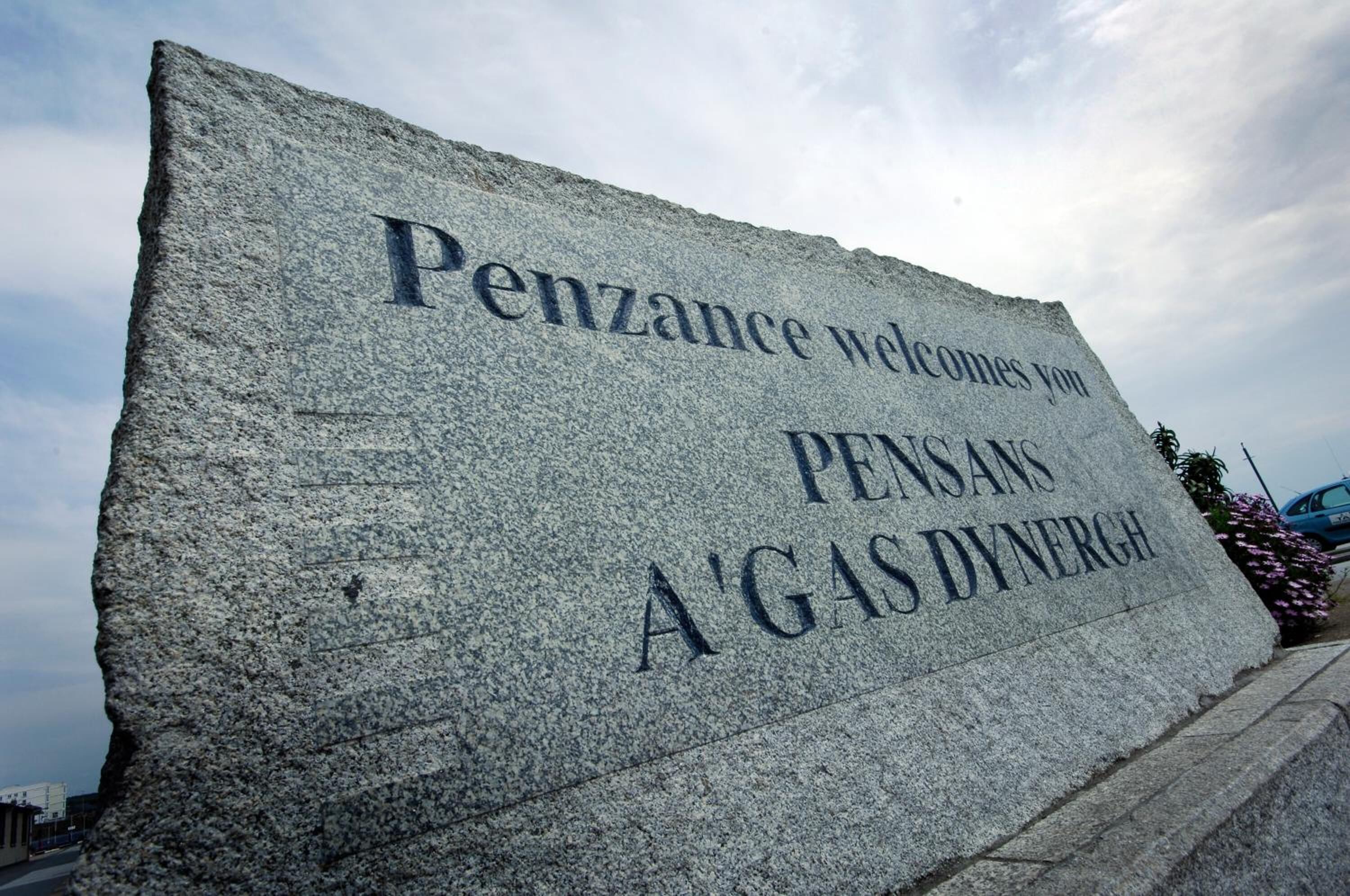 A stone sign with the text "Penzance welcomes you" and "PENSANS A'GAS DYNERGH".