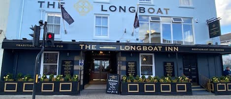 A building with the sign "The Longboat Inn" indicating it is a restaurant and rooms establishment.