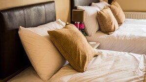 A hotel room with two beds, each with a dark headboard and white bedding. - The Longboat Inn (Penzance)