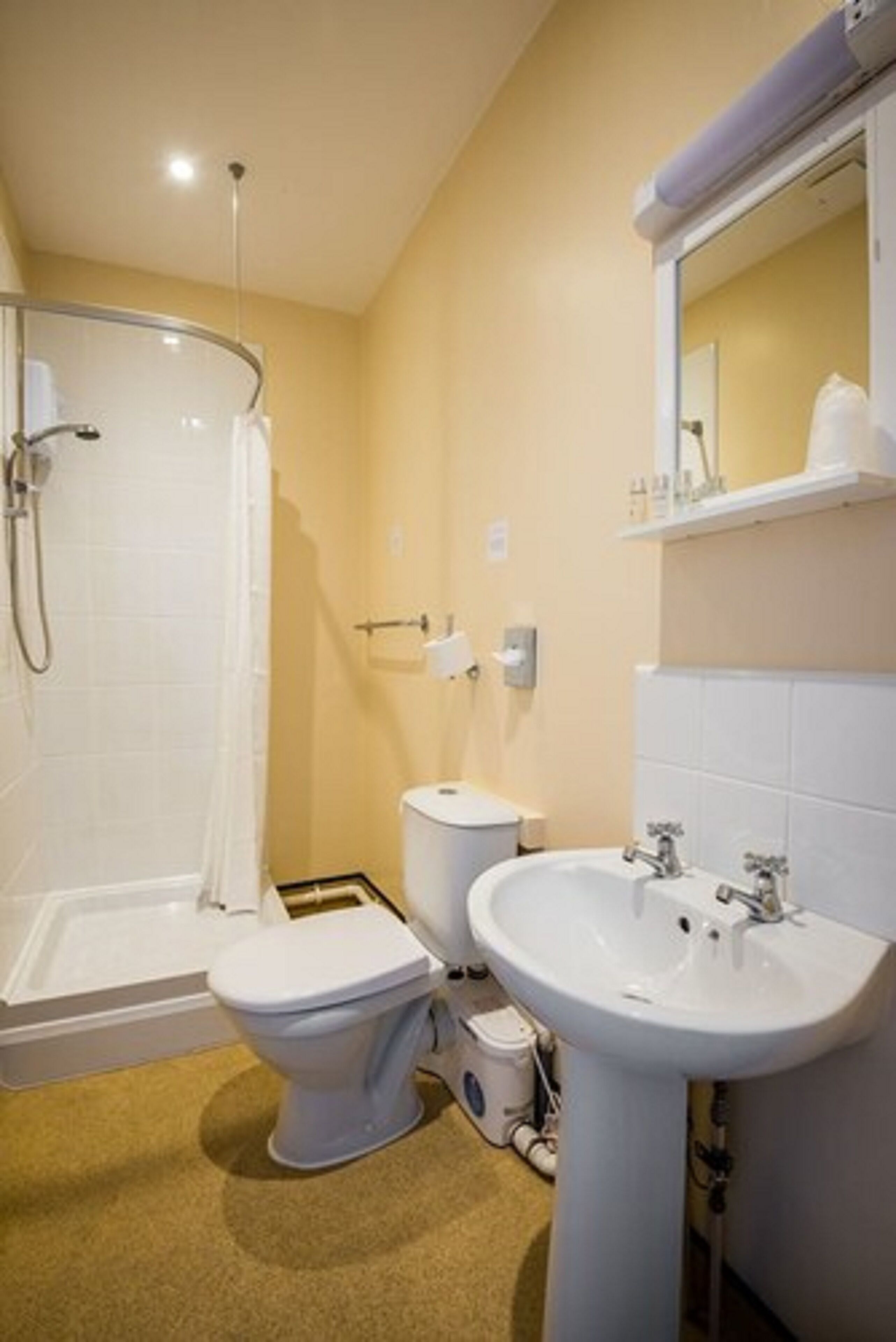 A bathroom with a shower, toilet, and sink.