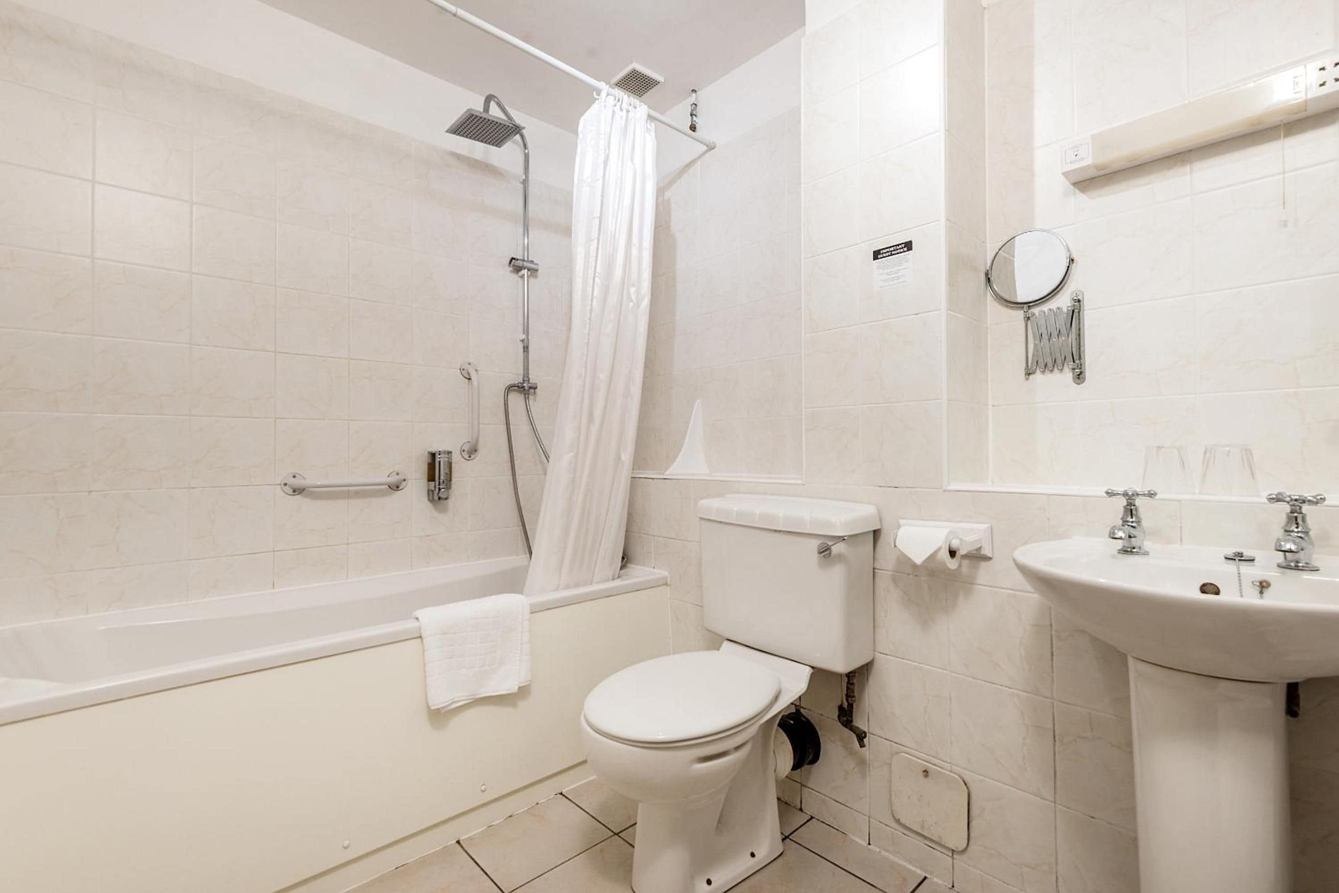 A bathroom with a bathtub, toilet, and sink.
