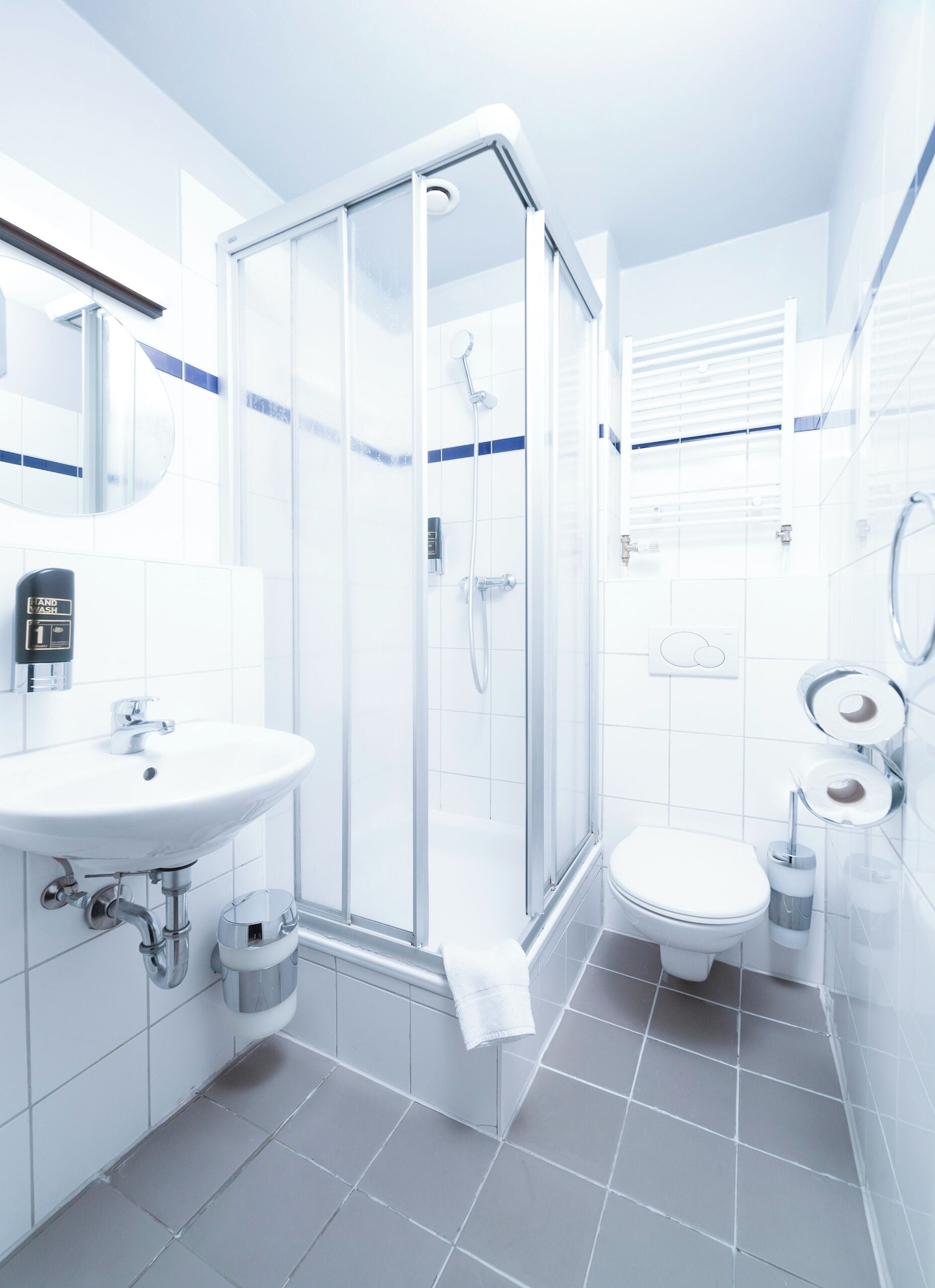 A modern bathroom with a glass shower enclosure, a sink, and a toilet.