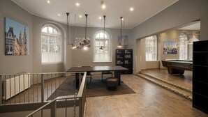 A spacious room with a pool table, bookshelves, and large windows. - a&o Wien Stadthalle (Vienna)