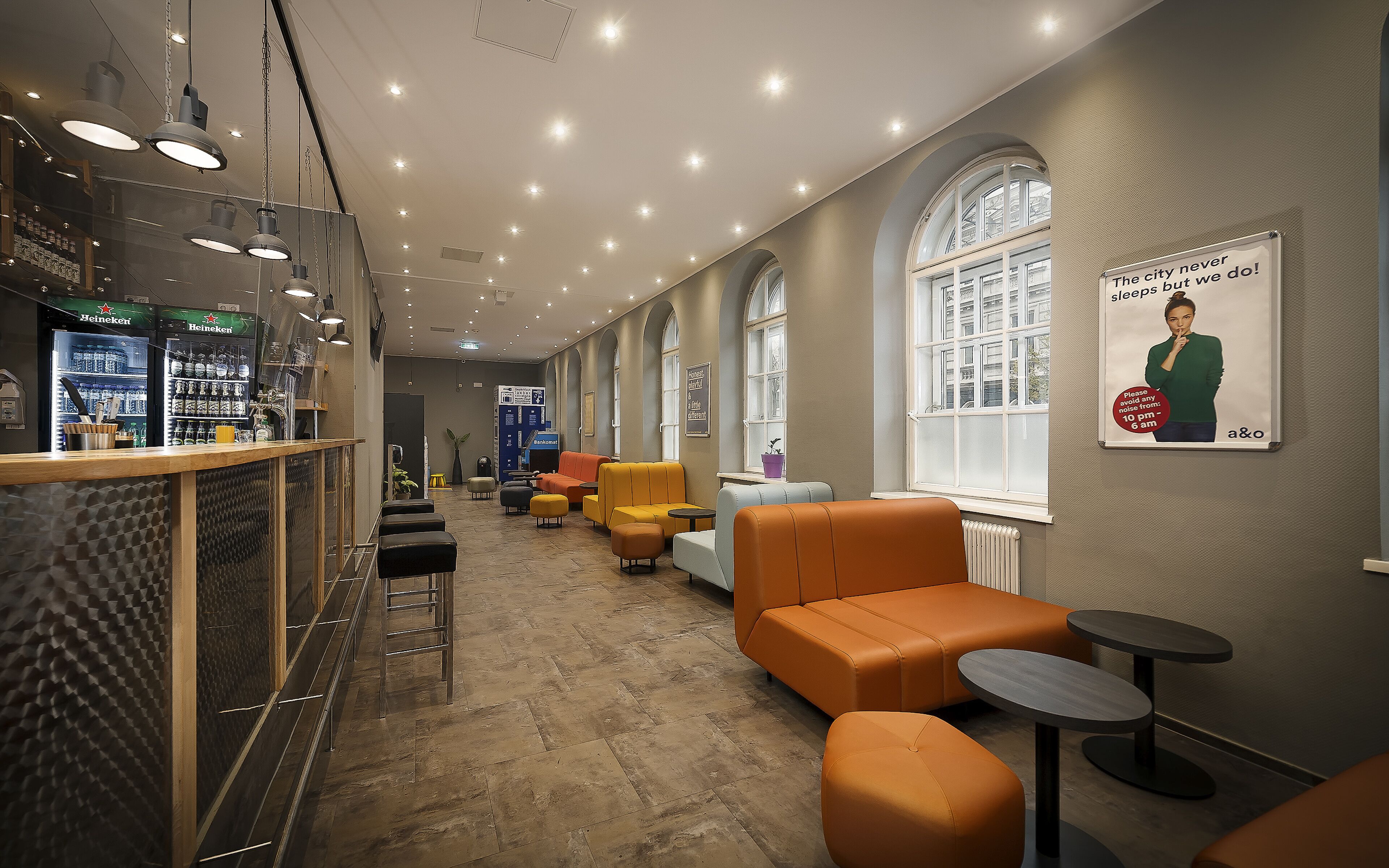 A modern lounge area with seating, a bar, and a large window.