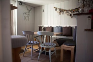 Een eethoek met houten stoelen, een bank en een tafel.