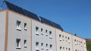 Un bâtiment doté de nombreuses fenêtres et de panneaux solaires sur le toit.