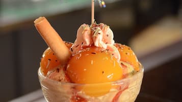 A dessert in a glass bowl with a stick on top.