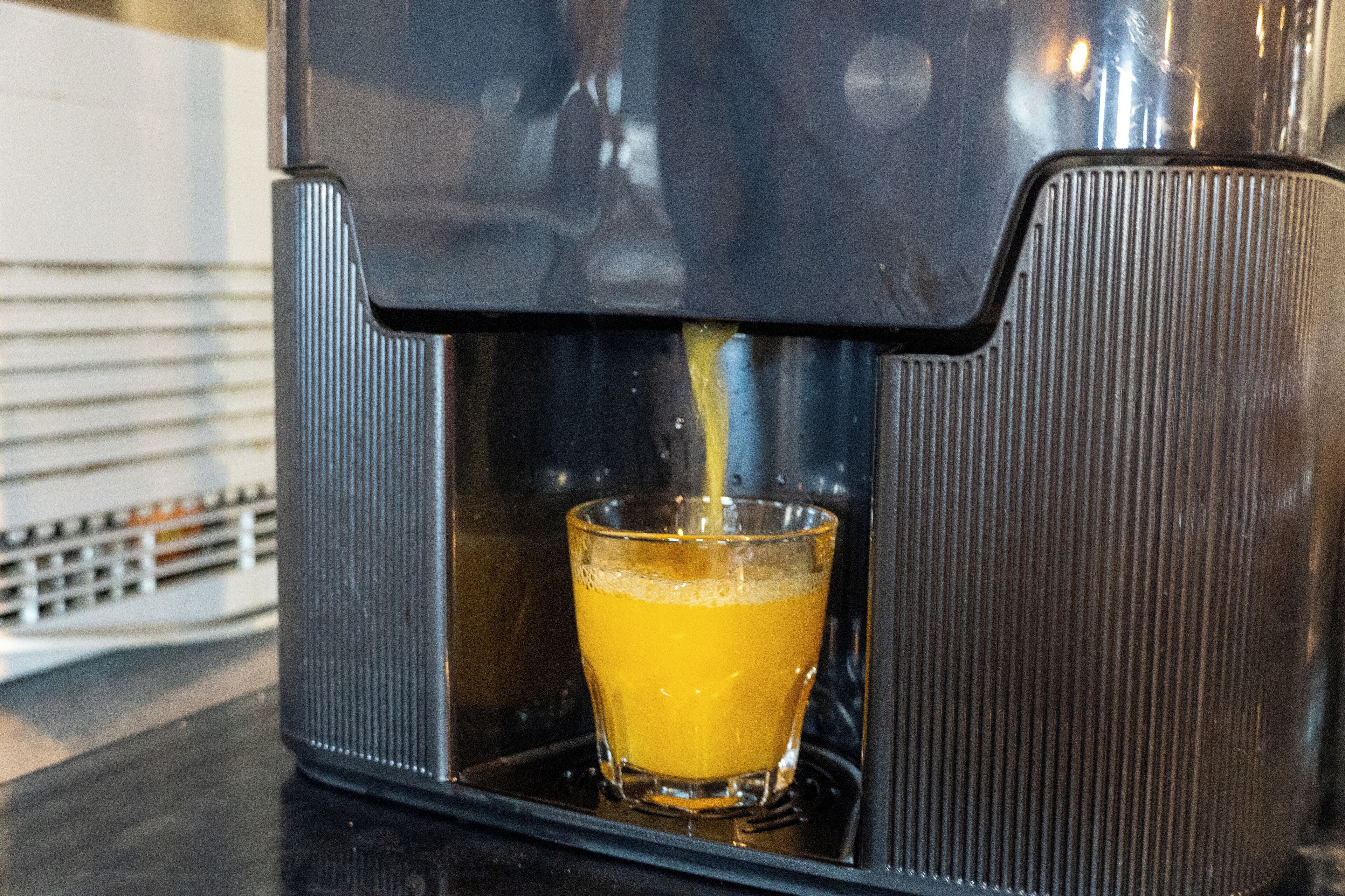 A coffee machine dispensing coffee into a glass.
