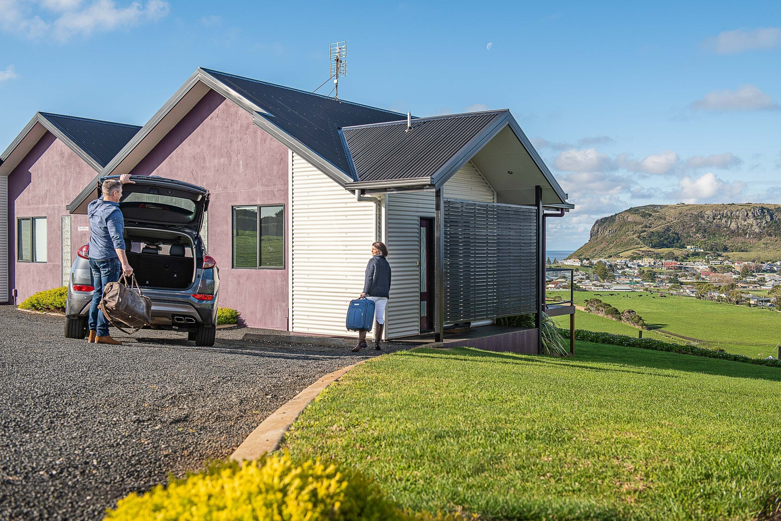 A house with a garage, a driveway, and a grassy area.