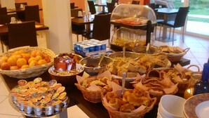 Una mesa de buffet con diferentes opciones de comida, como frutas, pasteles y pan.