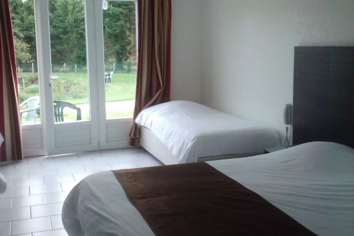 Ein Schlafzimmer mit zwei Betten, einem Deckenventilator und einer Glastür, die zu einem Außenbereich führt.