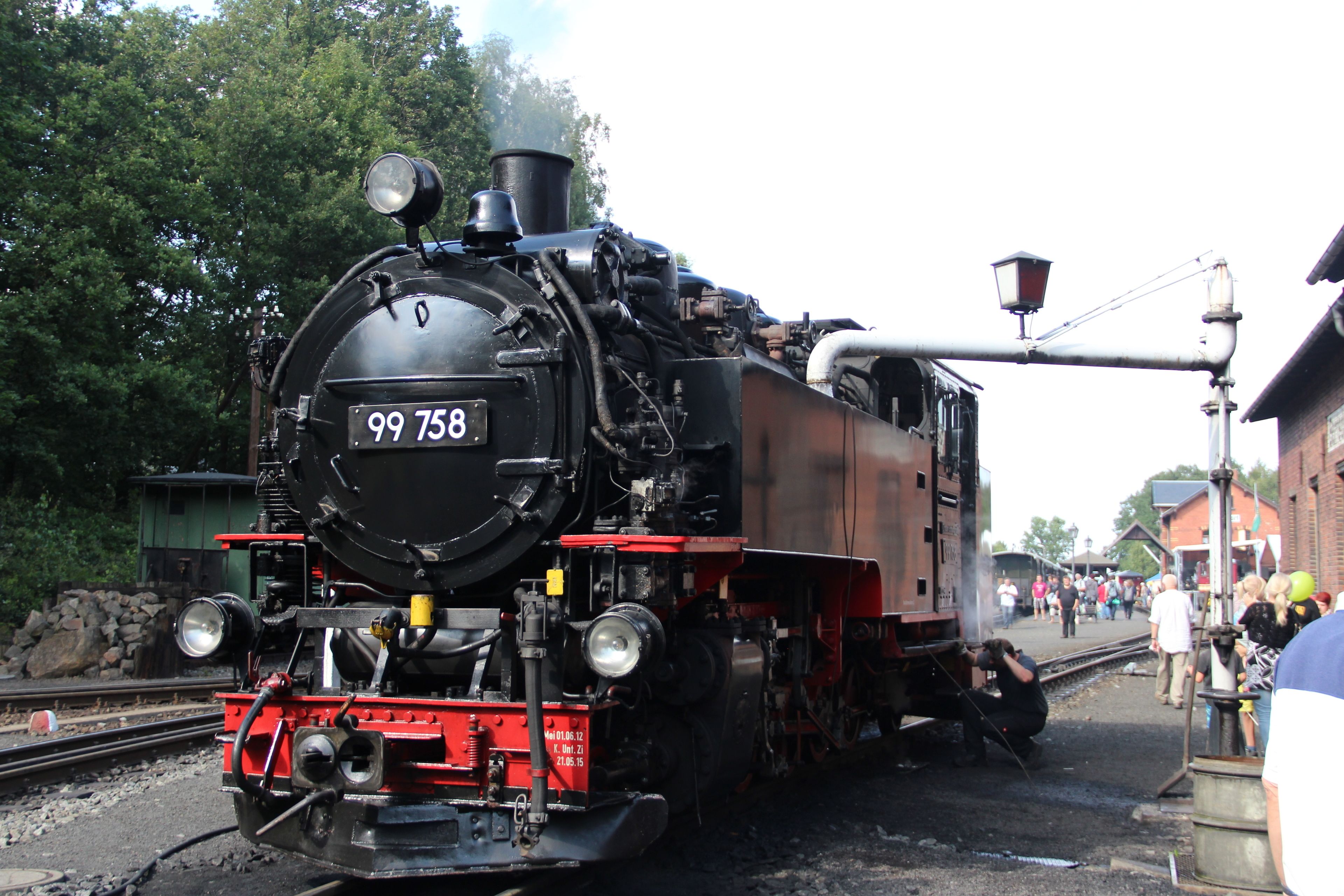 Uma locomotiva a vapor com o número 99758 em uma estação.