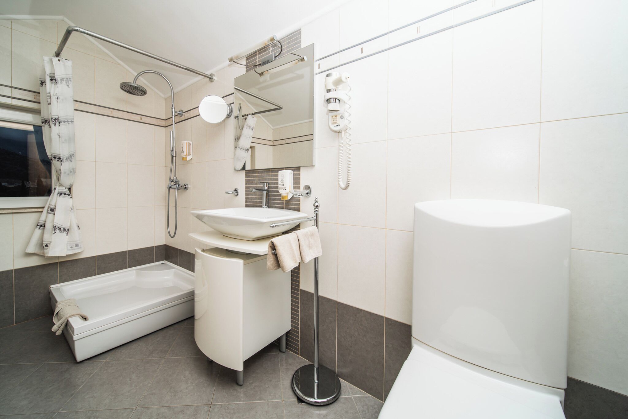 A modern bathroom with a bathtub, a sink, a shower, and a toilet.