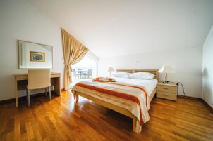Un dormitorio con una cama de madera, un escritorio, una silla y una ventana con cortinas.
