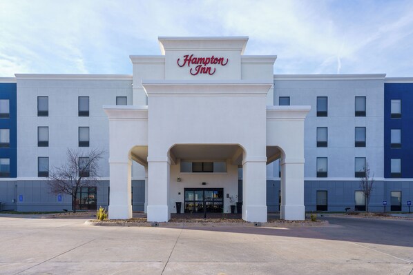 A Hampton Inn hotel entrance with a modern facade, large windows, and a clear sky. - Hampton Inn Garden City (Garden City)