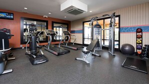 A gym with treadmills, a bench, a squat rack, and a variety of weights. - Hampton Inn & Suites Danville (Danville)