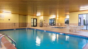An indoor swimming pool with a wooden ceiling, tiled walls, and a seating area with chairs and tables. - Hampton Inn & Suites Danville (Danville)
