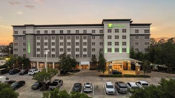 A Holiday Inn hotel with a parking lot and a well-lit entrance.