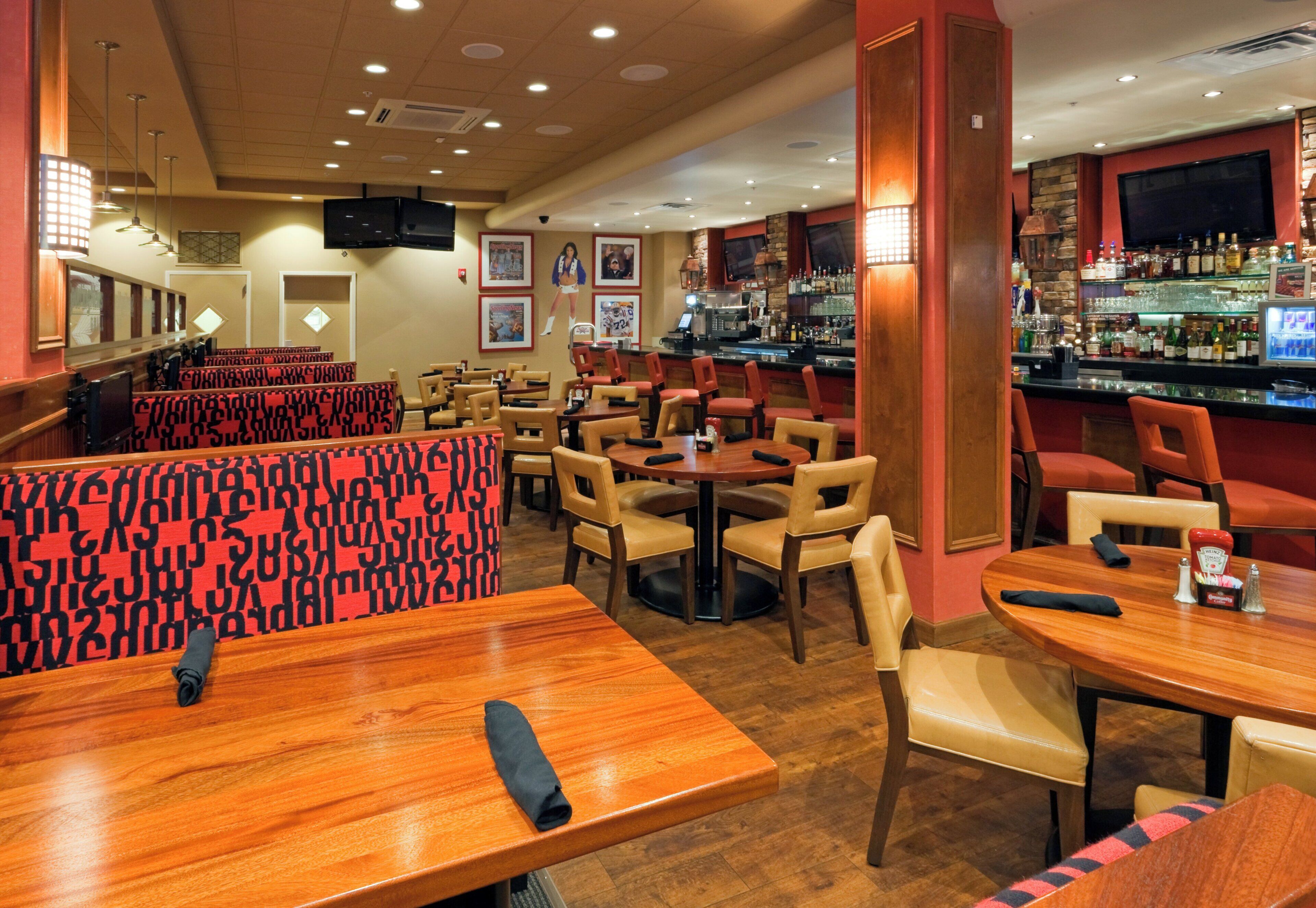 A restaurant interior with booths, tables, and a bar area.