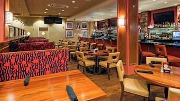 A restaurant interior with booths, tables, and a bar area.