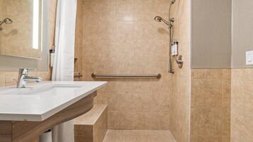 A bathroom with a shower, a sink, and a mirror.