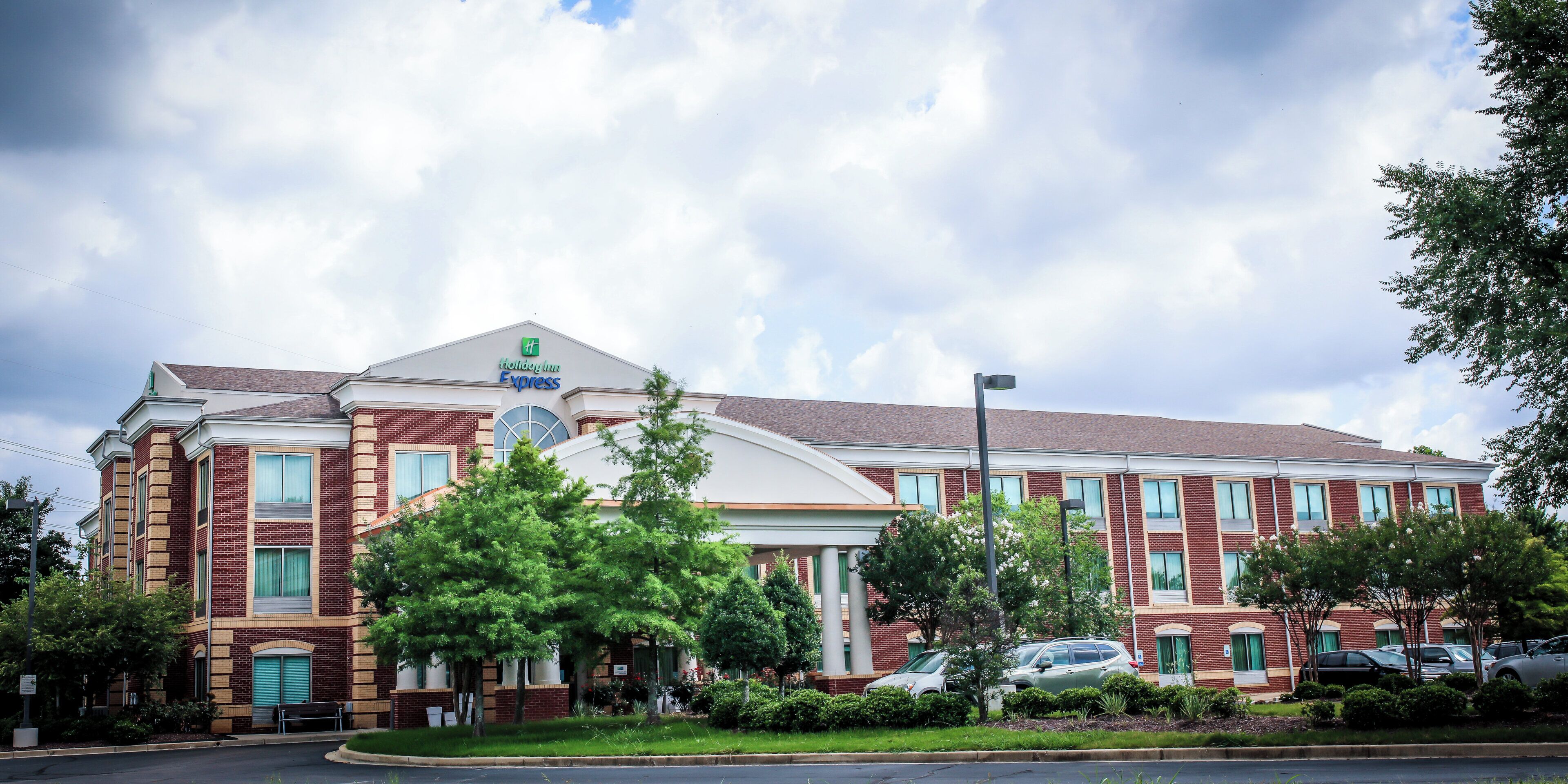 A Holiday Inn Express hotel with a brick facade, large windows, and a prominent sign.