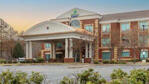 A Holiday Inn Express building with a covered entrance, brick facade, and large windows.