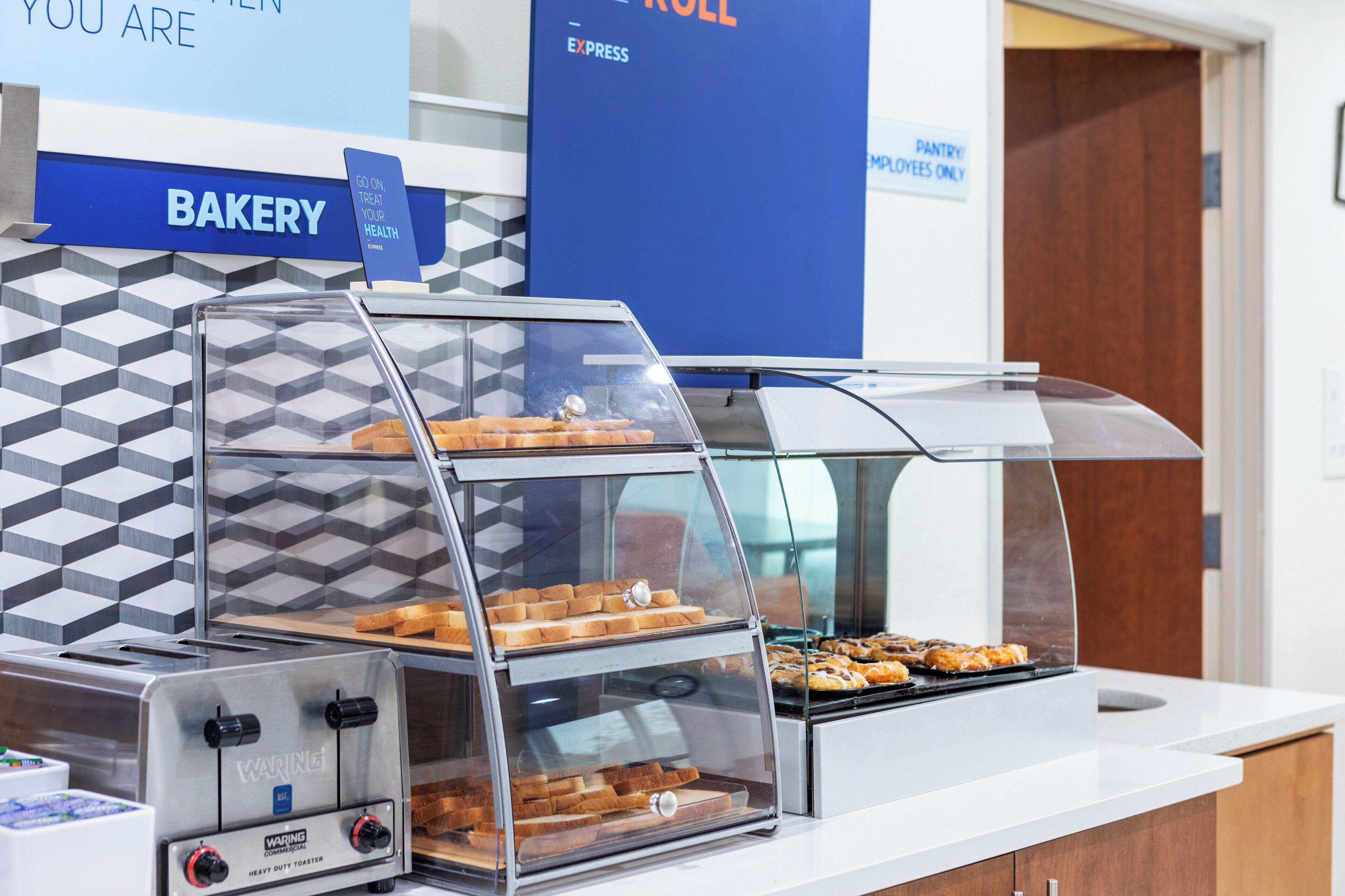 A bakery counter with a display case containing bread and pastries.